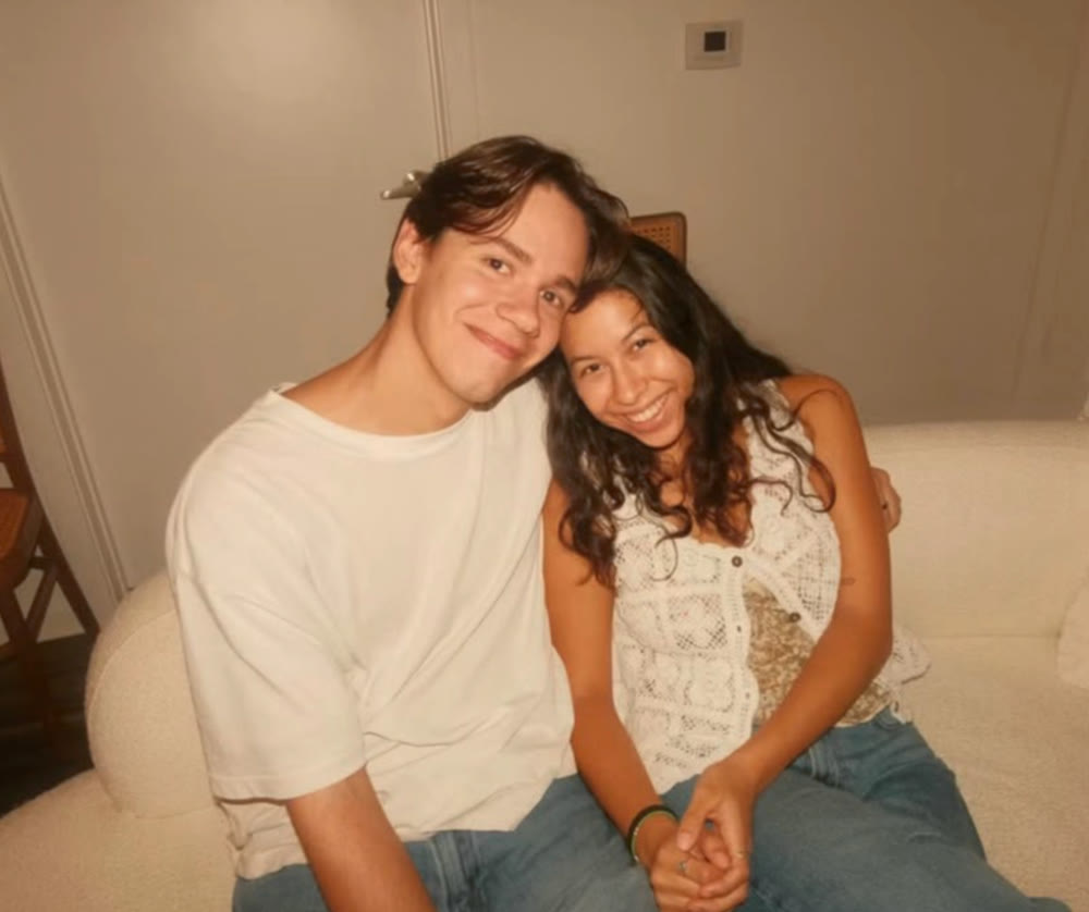 Two friends smiling together on a sofa