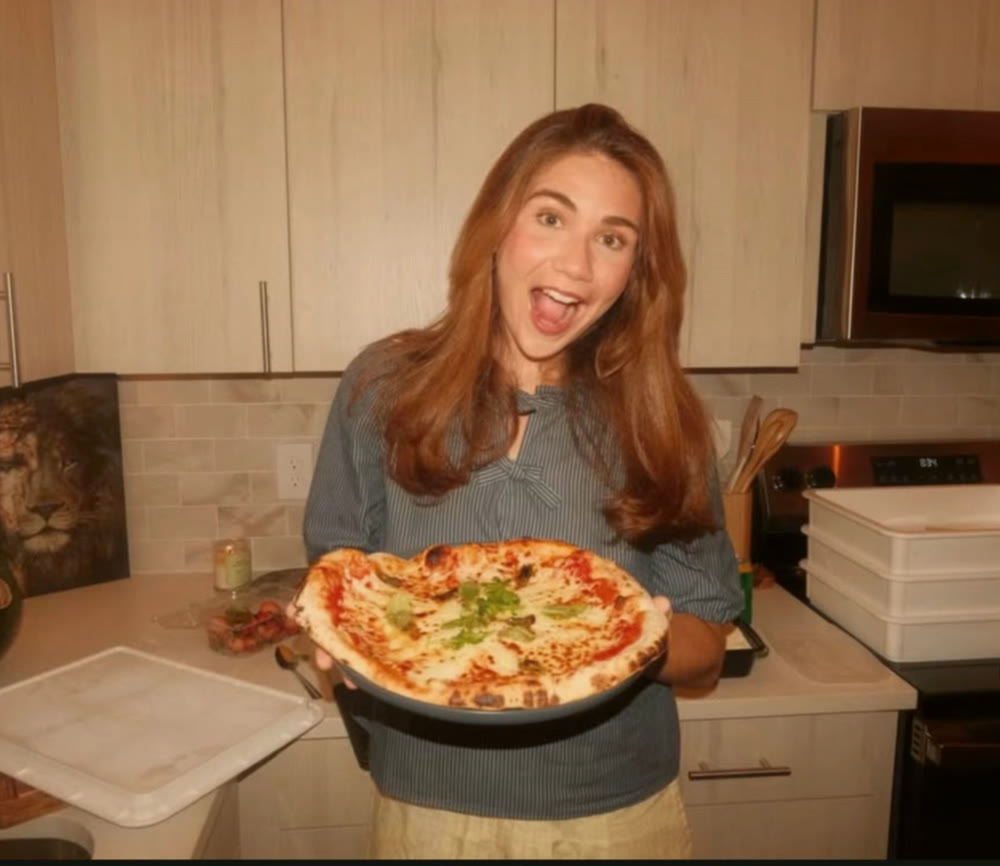 A friend cheering while holding a fresh Margherita